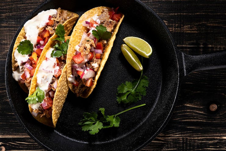 Cajun-spiced salmon chunks in a taco topped with fresh greens and yogurt dressing.