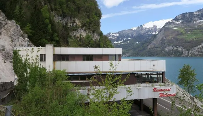 A shot of the modernist architecture of the Grill Café Walensee, capturing the view of the lake behind the glass.