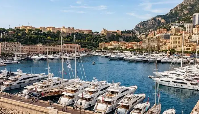 Harbor view of Monte Carlo in Monaco featuring luxury yachts along the French Riviera.